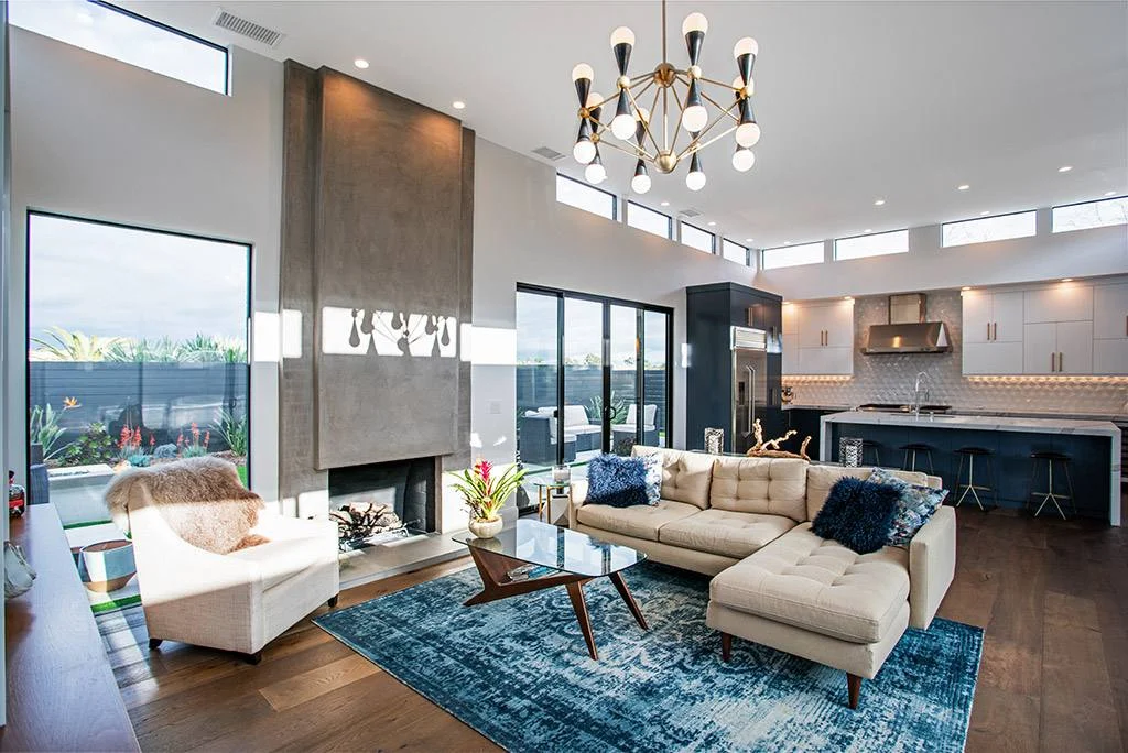 Mid-century modern living room with concrete fireplace column, clerestory windows and brass chandelier
